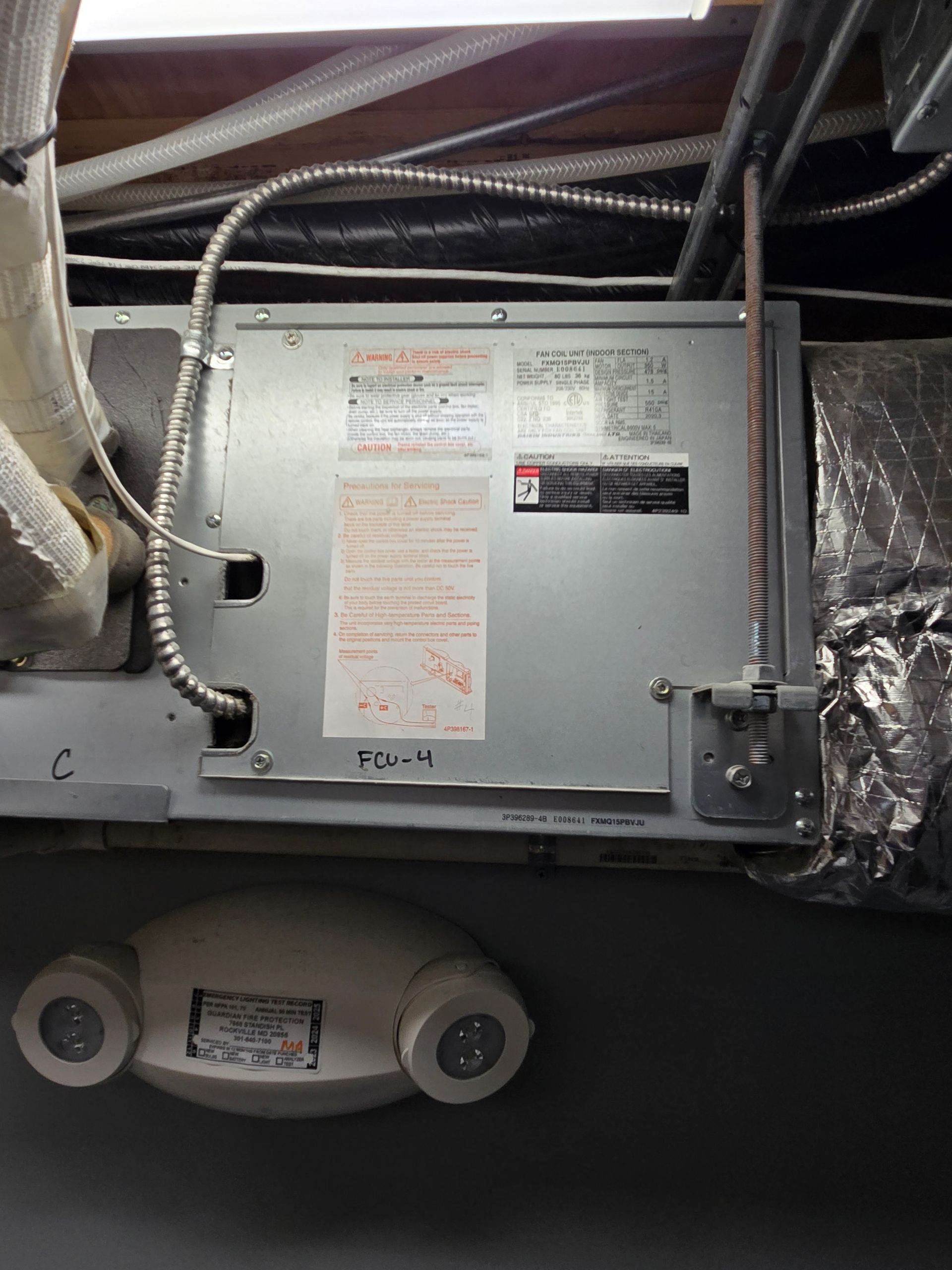 HVAC unit inside a ceiling cavity with ducts, wiring, and insulation around it
