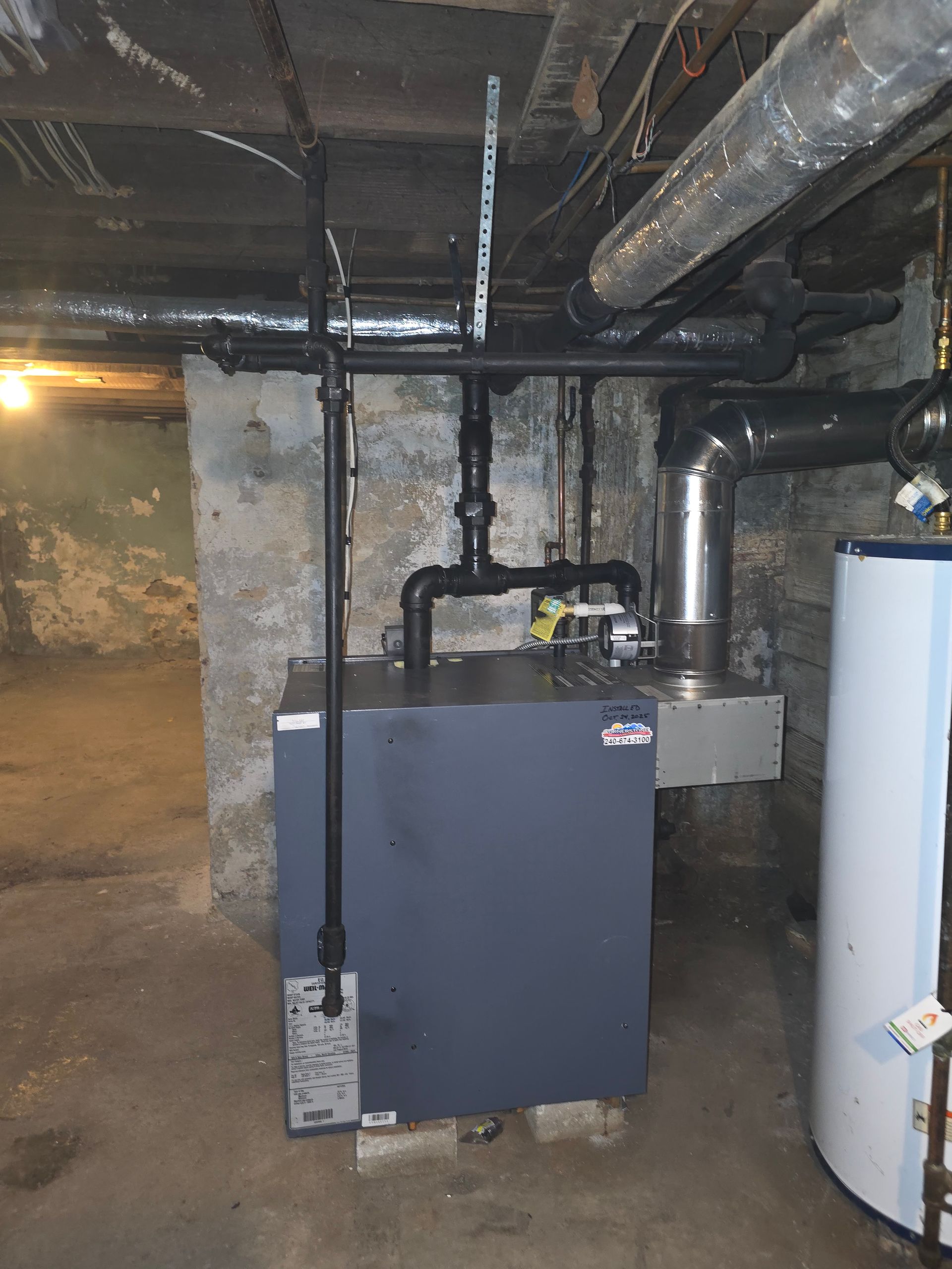 Basement utility room with furnace, water heater, and exposed pipes and ducts