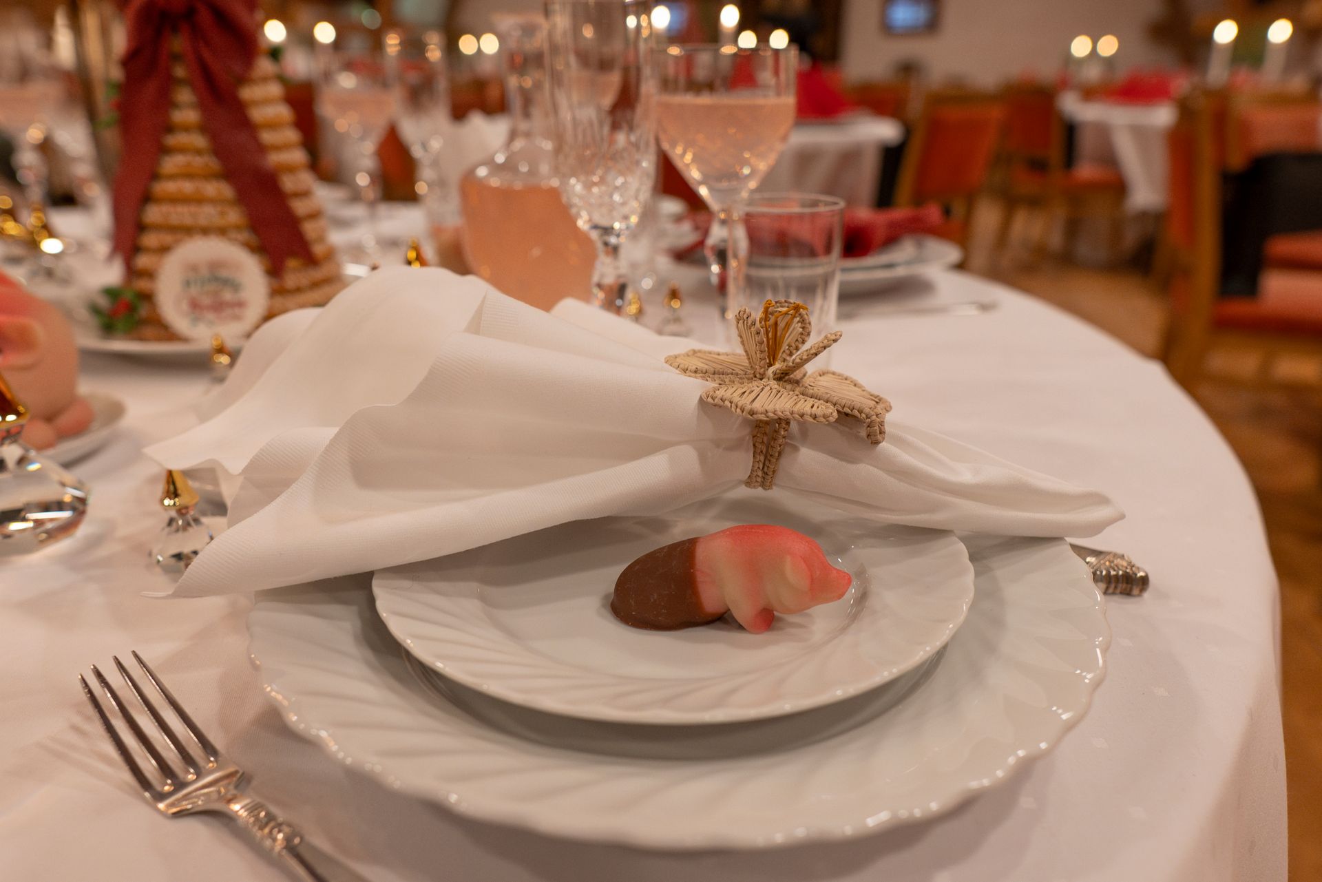 Elegant bankettbord dekket med hvite tallerkener, brettede servietter og gullstjernedekorasjoner i en varmt opplyst hall