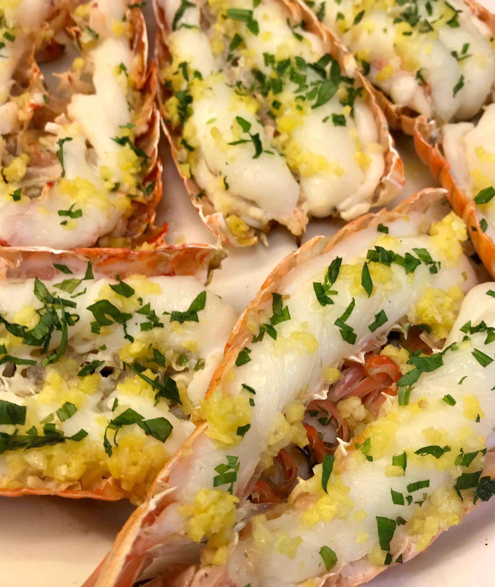 Et fat med delte, stekte sjøkreps toppet med hvitløk, smør og fersk hakket persille.