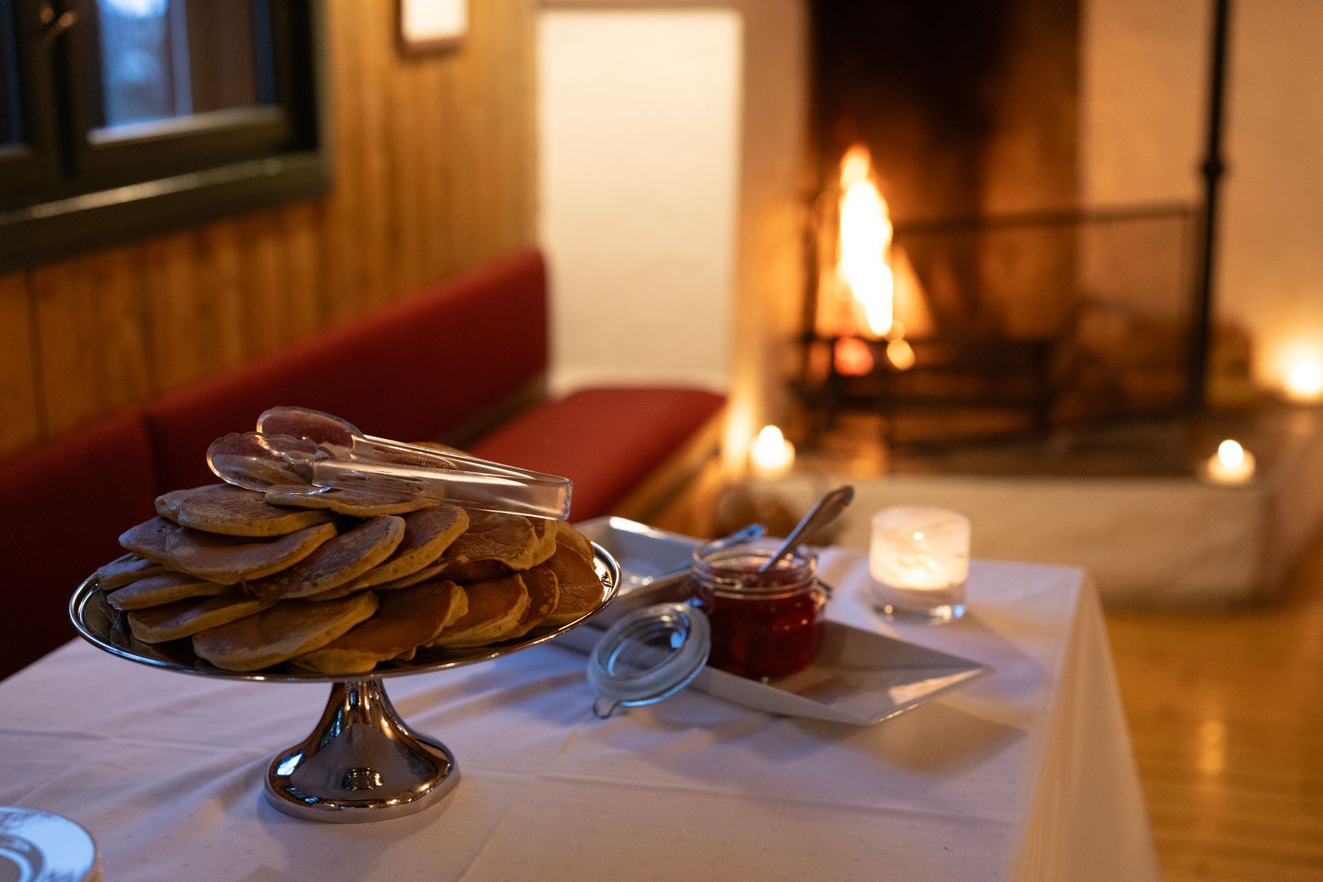 Dessertbrett på et hvitt bord ved siden av en tent peis i et koselig rom