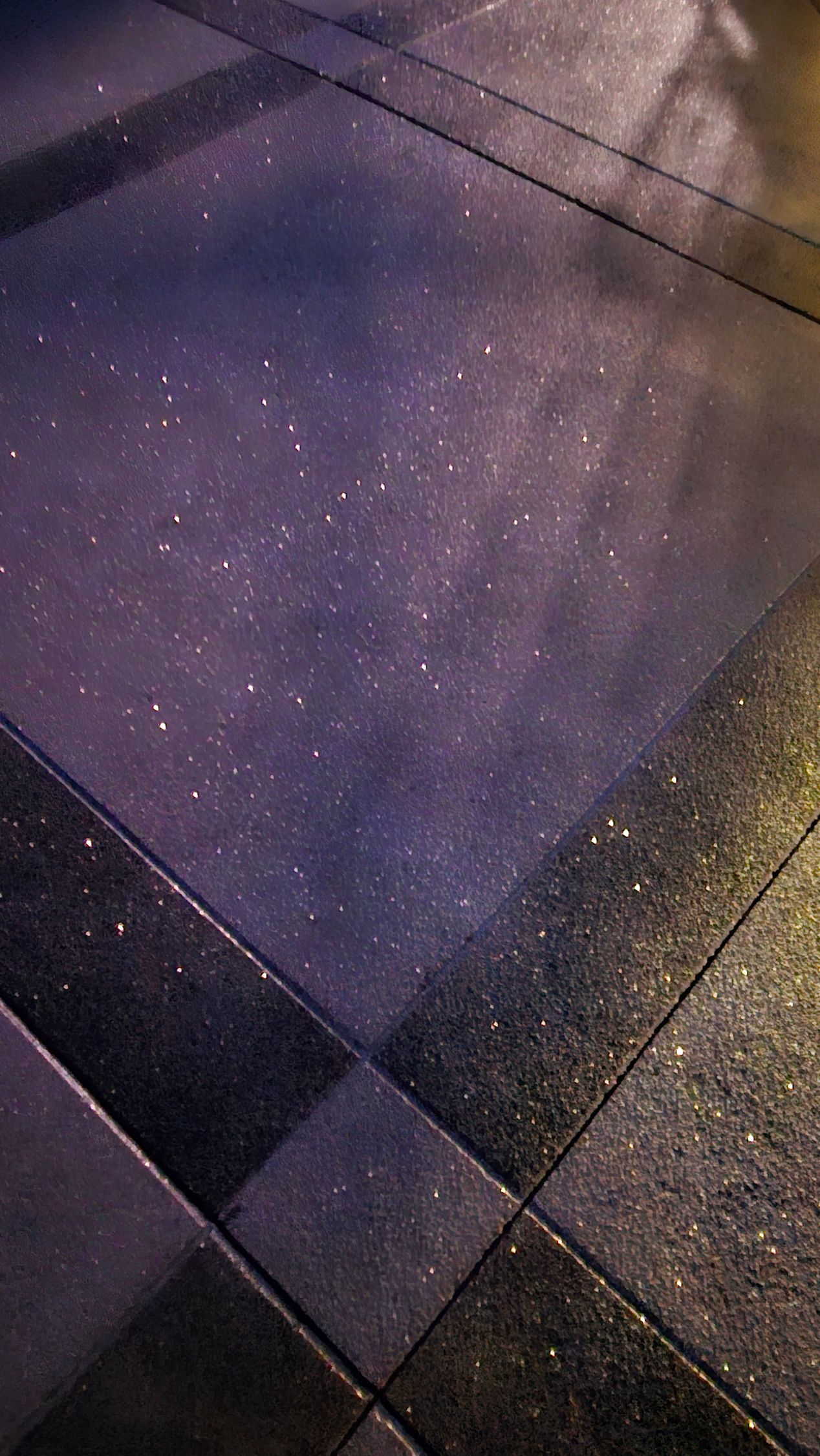 Tiled ground surface featuring dark gray squares and patches of purple lighting or reflection.
