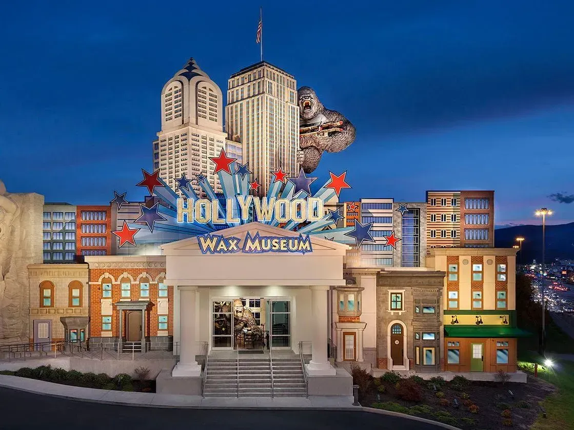 Universal Studios Hollywood entrance sign at dusk with city-style buildings and blue sky