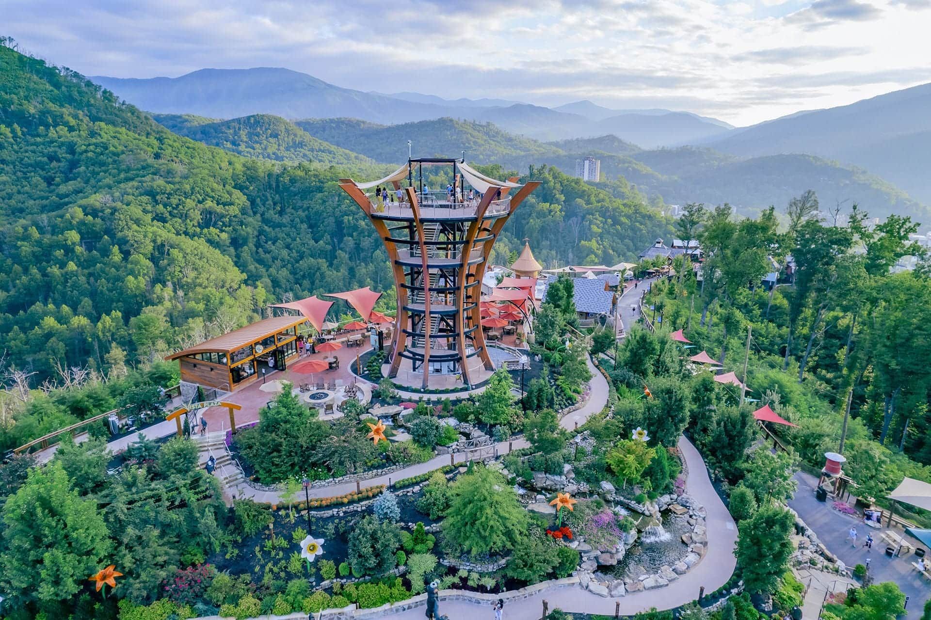 Mountain temple pavilion with colorful rooftops amid lush green hills and winding paths