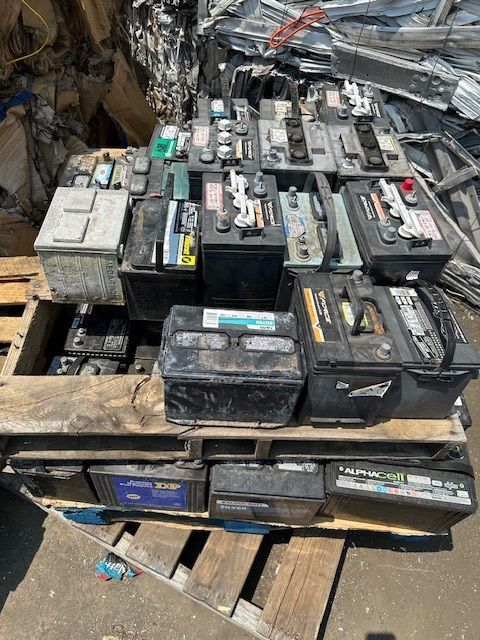 A pile of batteries sitting on top of a wooden pallet.