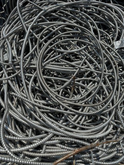 A pile of metal wires sitting on top of each other on the ground.