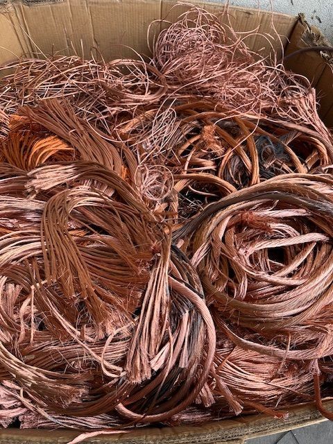 A pile of copper wire is sitting in a cardboard box.