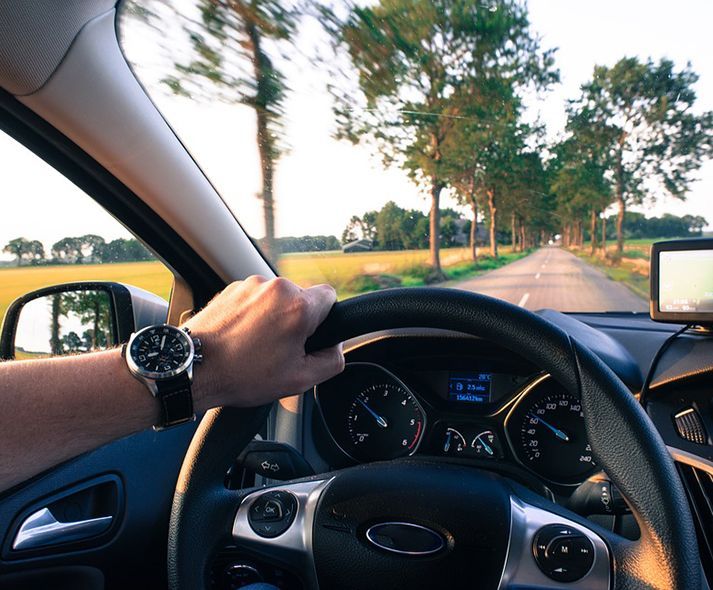 Une personne conduit une voiture sur une route de campagne.