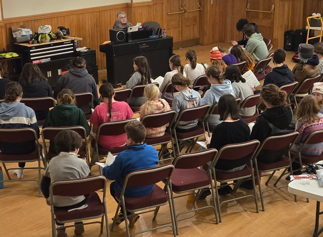 A group of people are sitting in chairs in a large auditorium.