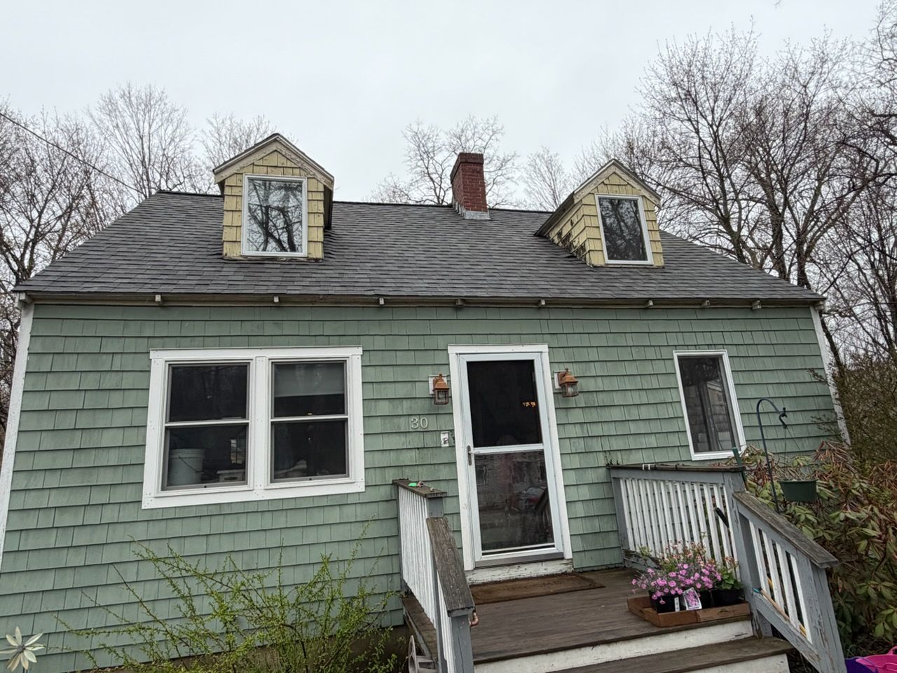Insulated attic crawlspace with exposed wooden beams and a dark opening in the roof area