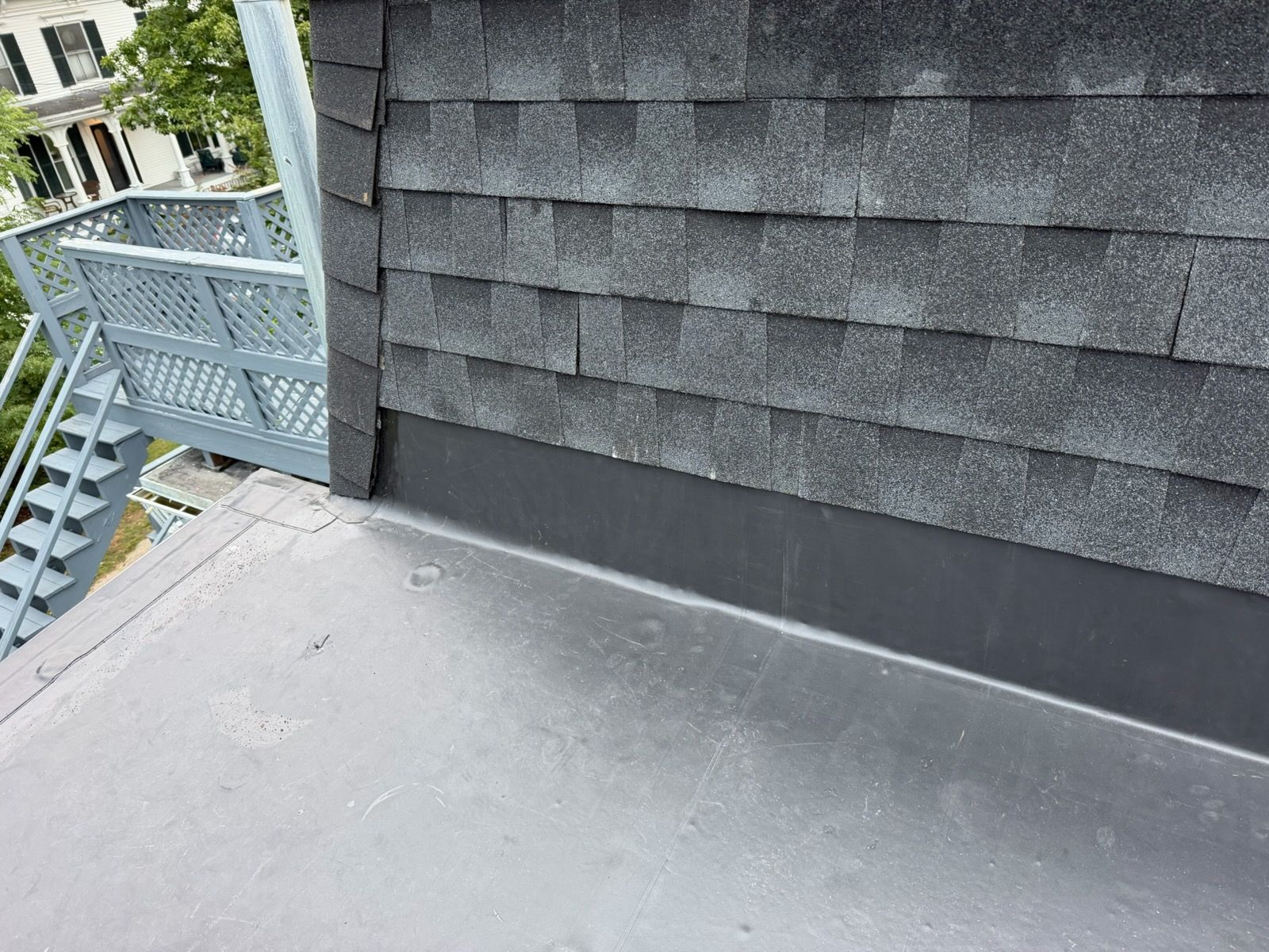 Insulated attic crawlspace with exposed wooden beams and a dark opening in the roof area