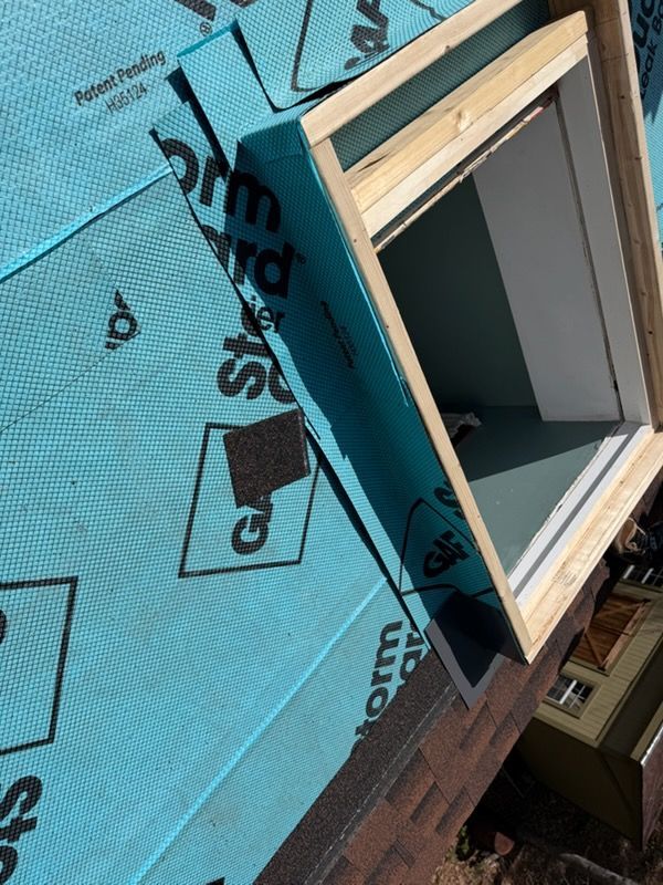 Blue roof underlayment with a skylight window frame and black printed markings
