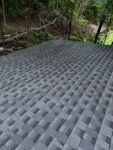 Gray textured mat or platform outdoors beside a wooded stream