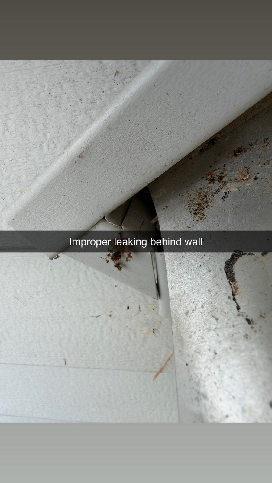 Close-up of white painted surfaces with a dark crack and brown rust stains in the corner.