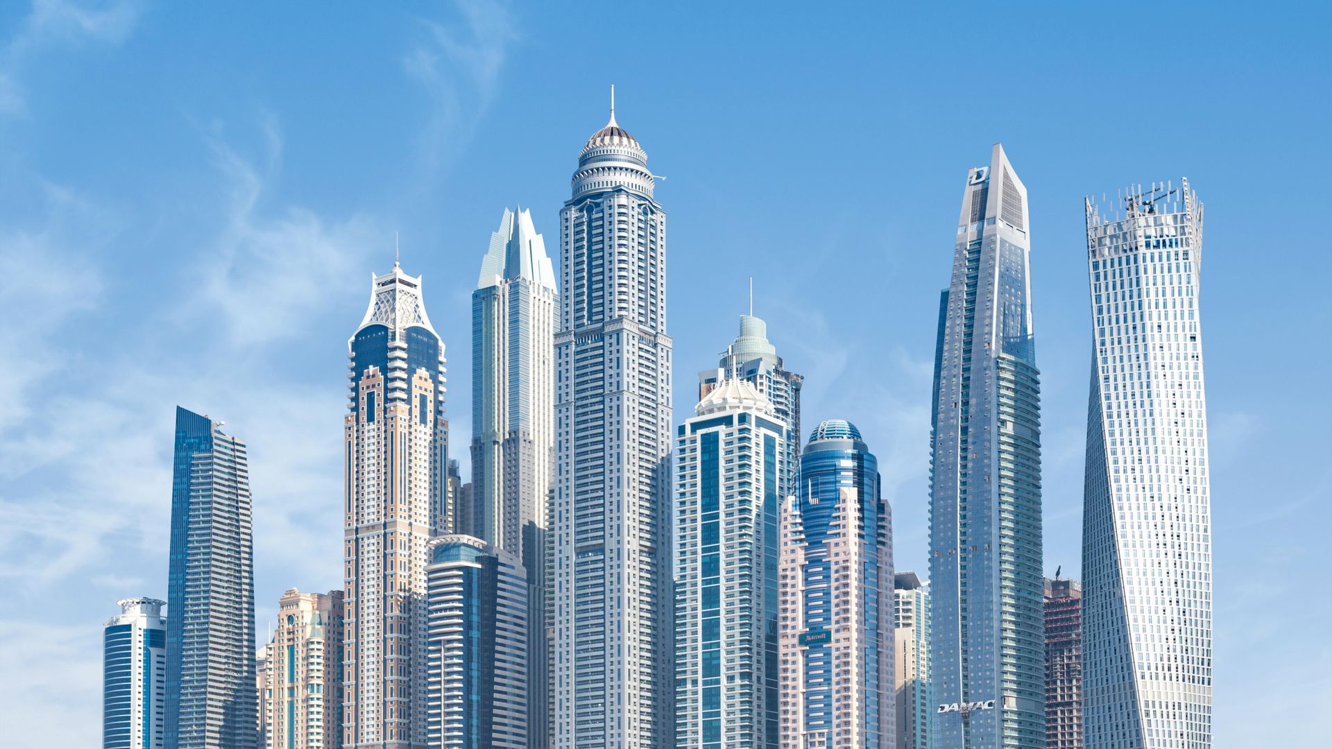 Skyscrapers against a bright blue sky, showcasing modern architecture in Dubai.