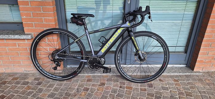 Una bicicletta è parcheggiata davanti a un edificio in mattoni.