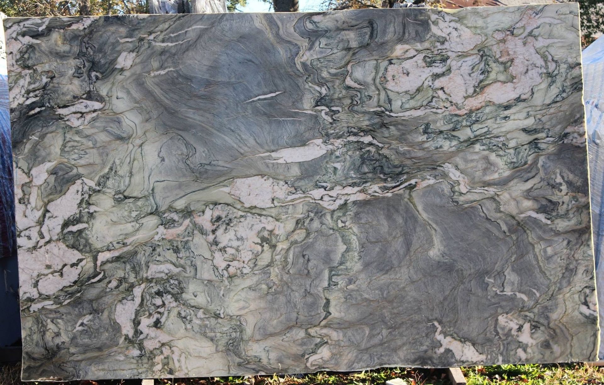Gray and white veined marble slab with a polished, textured surface