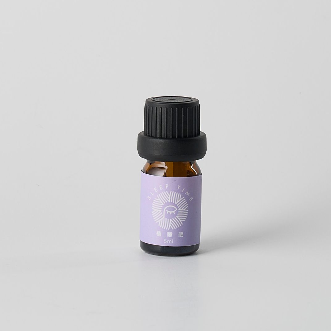 白色背景上的小型棕色精油瓶，帶有紫色標籤和黑色瓶蓋。
