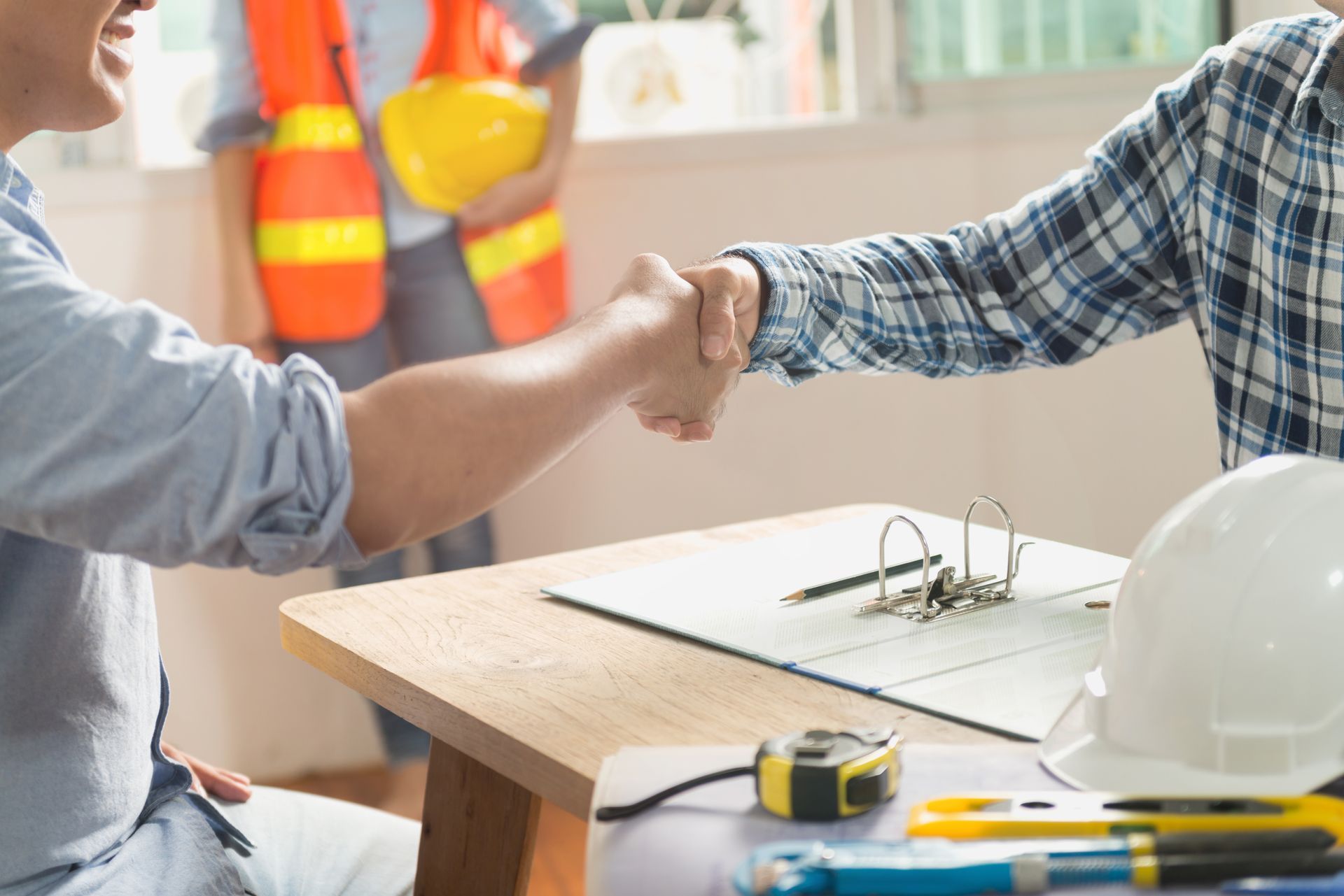 Deux hommes se serrent la main autour d'une table.