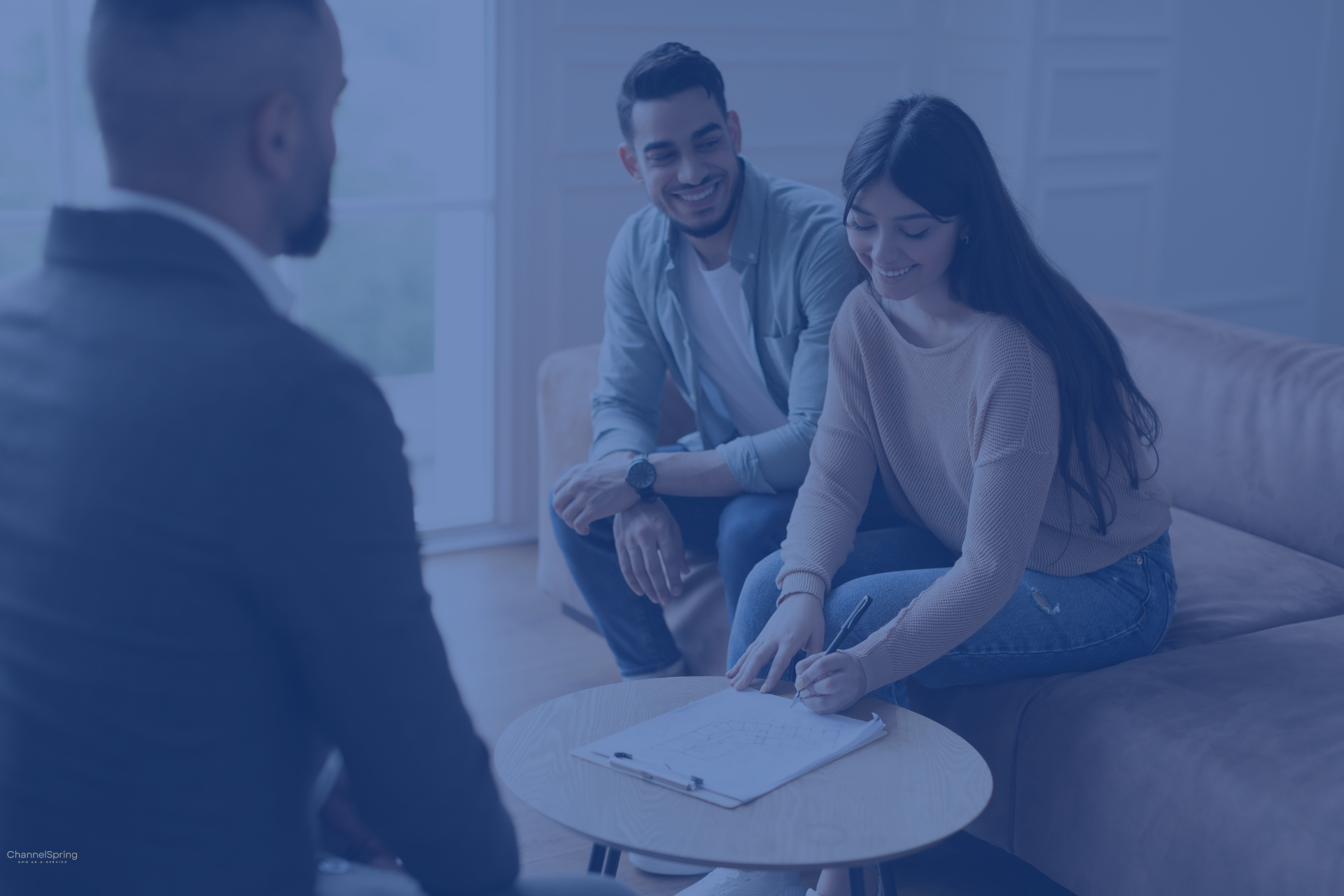 Reviews an engagement contract with two business owners as one signs at the table.