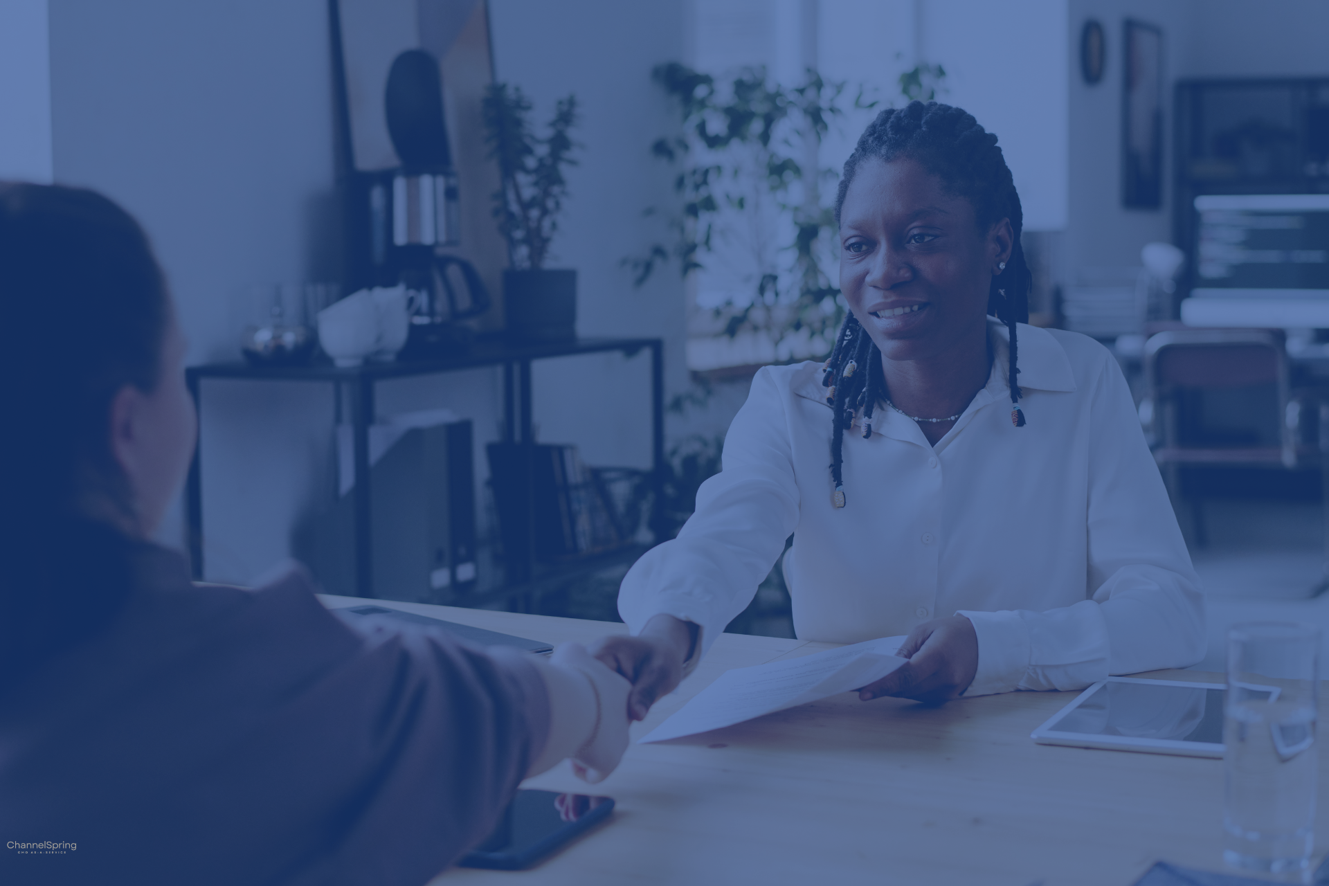 Business professional shaking hands during a marketing leadership meeting.