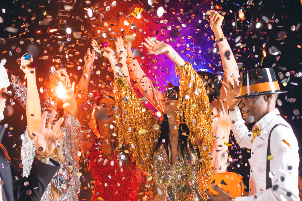 A man in a top hat is throwing confetti at a party