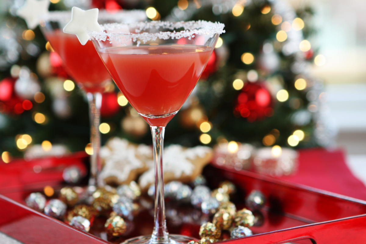 Two martini glasses on a tray with a christmas tree in the background
