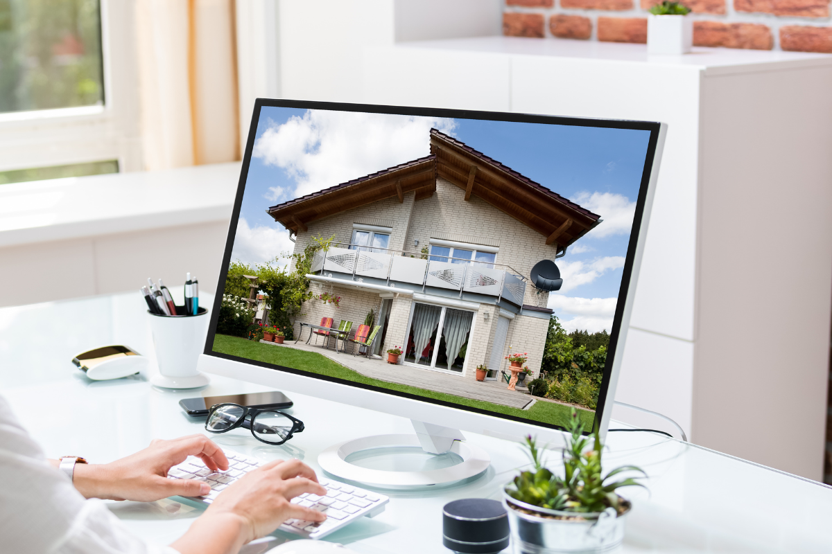 A person is using a computer with a picture of a house on the screen