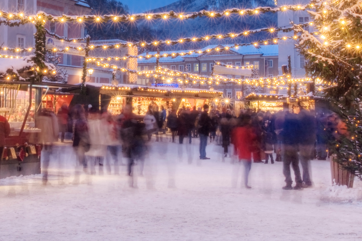 A blurry picture of people walking around a christmas market
