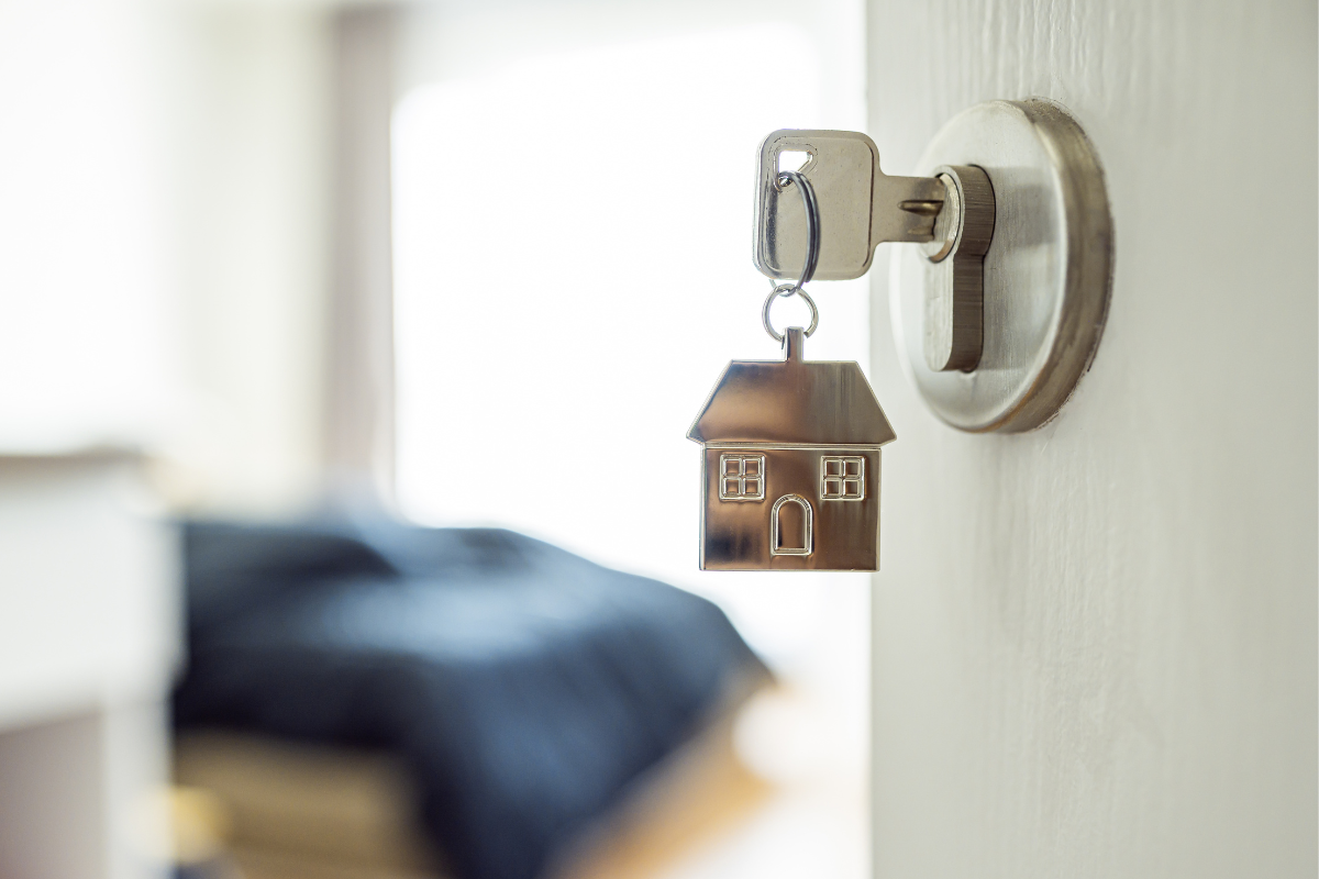 A key in a door with a house keychain attached to it
