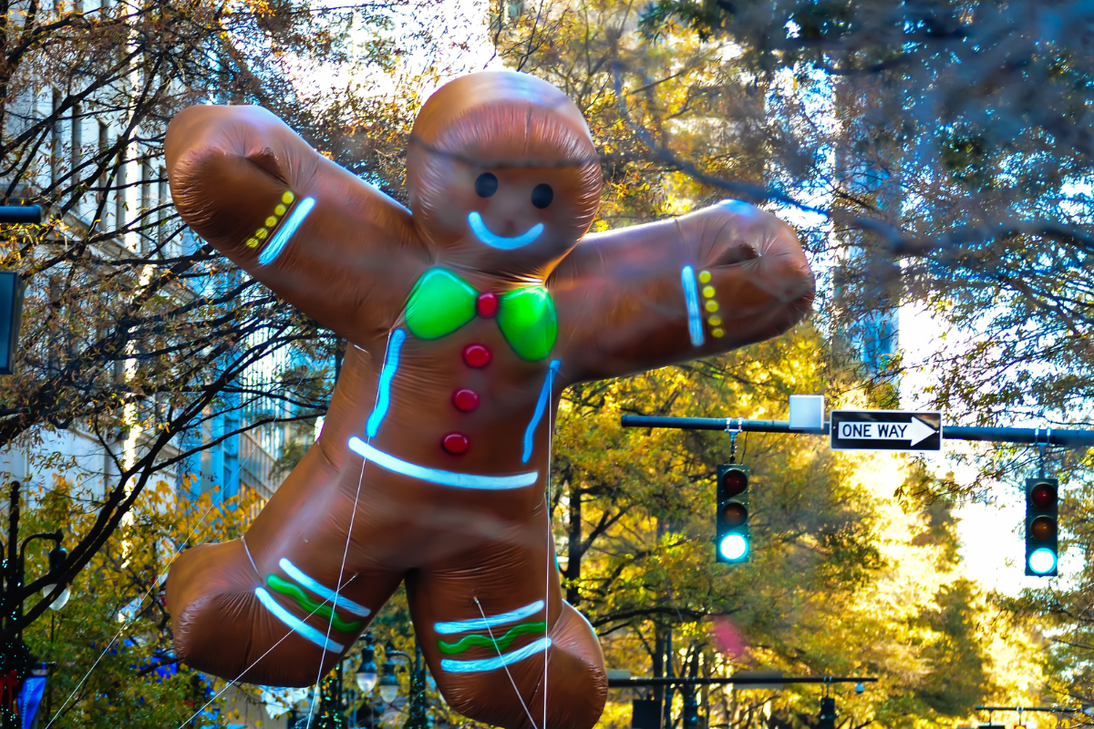 A giant inflatable gingerbread man is floating in the air
