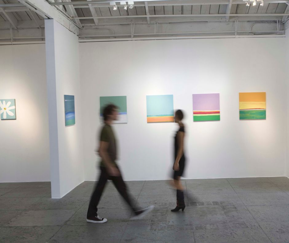 A man and a woman are walking through an art gallery