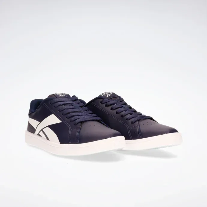 Zapatillas bajas azul marino oscuro con suela blanca y franja lateral sobre fondo blanco.