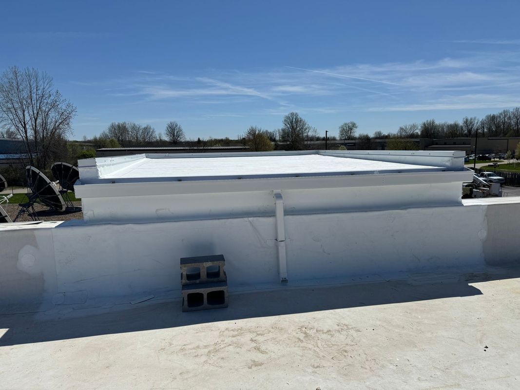 Flat, white commercial roof on a sunny day