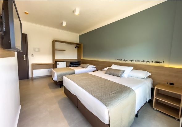 Um quarto de hotel com duas camas e uma TV de tela plana
