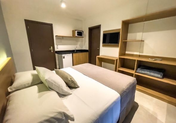 Um quarto de hotel com duas camas e uma cozinha.