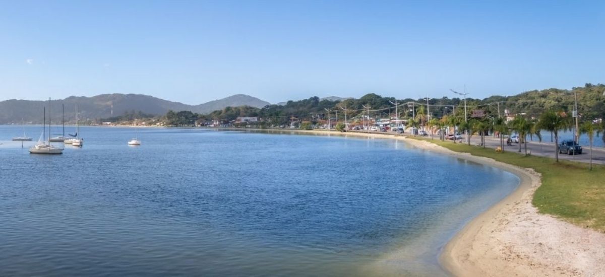 Um barco está flutuando em cima de um corpo de água próximo a uma praia.