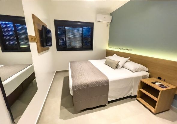 Um quarto de hotel com uma cama e um espelho