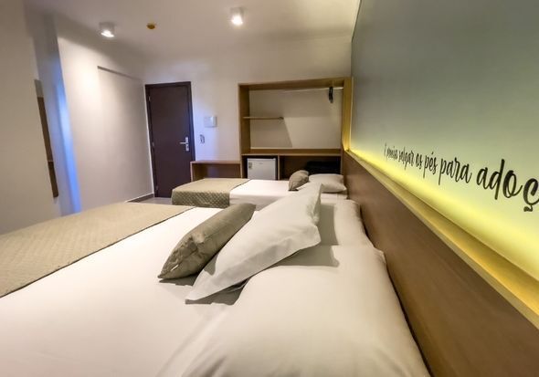 Um quarto de hotel com duas camas e uma placa na parede.