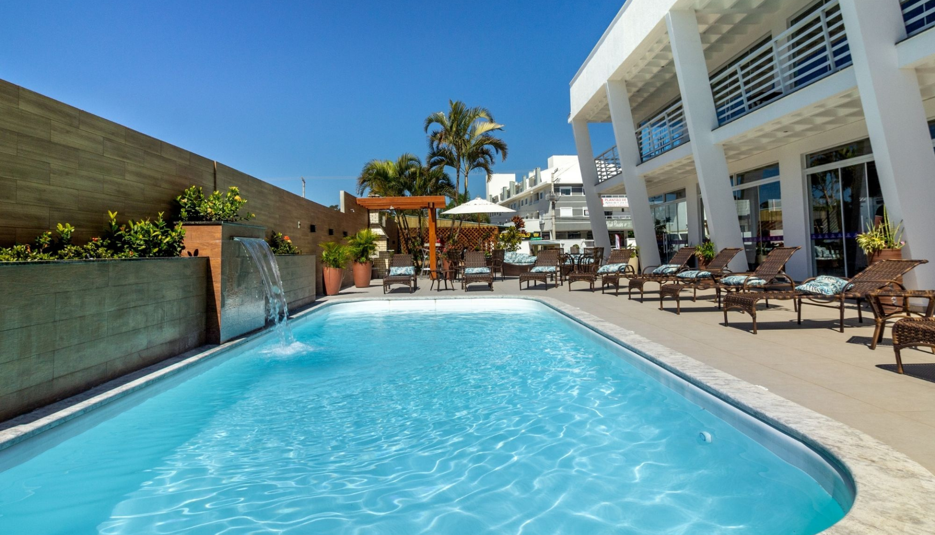 Uma grande piscina rodeada de cadeiras e um edifício.