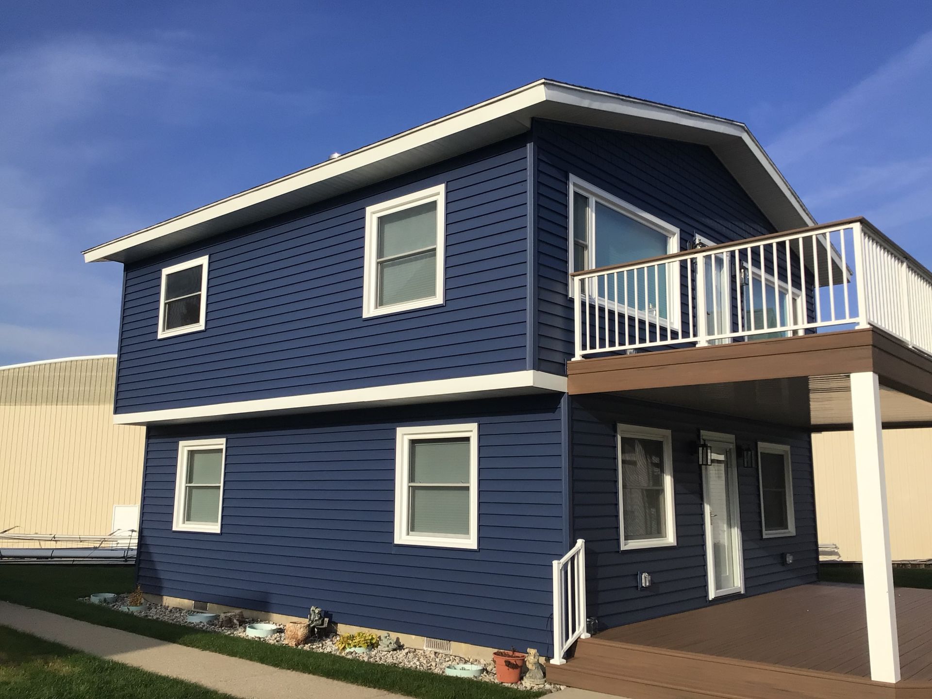 A blue house with a balcony and a blue sky in the background.