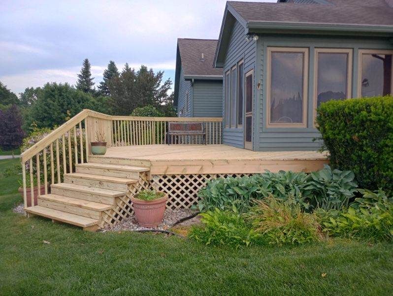 A house with a deck and stairs in front of it