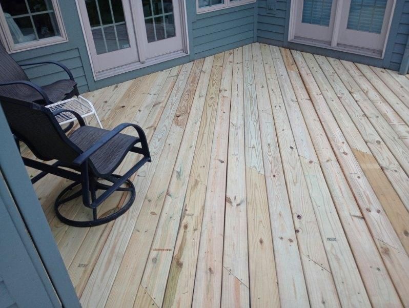 A wooden deck with a rocking chair on it