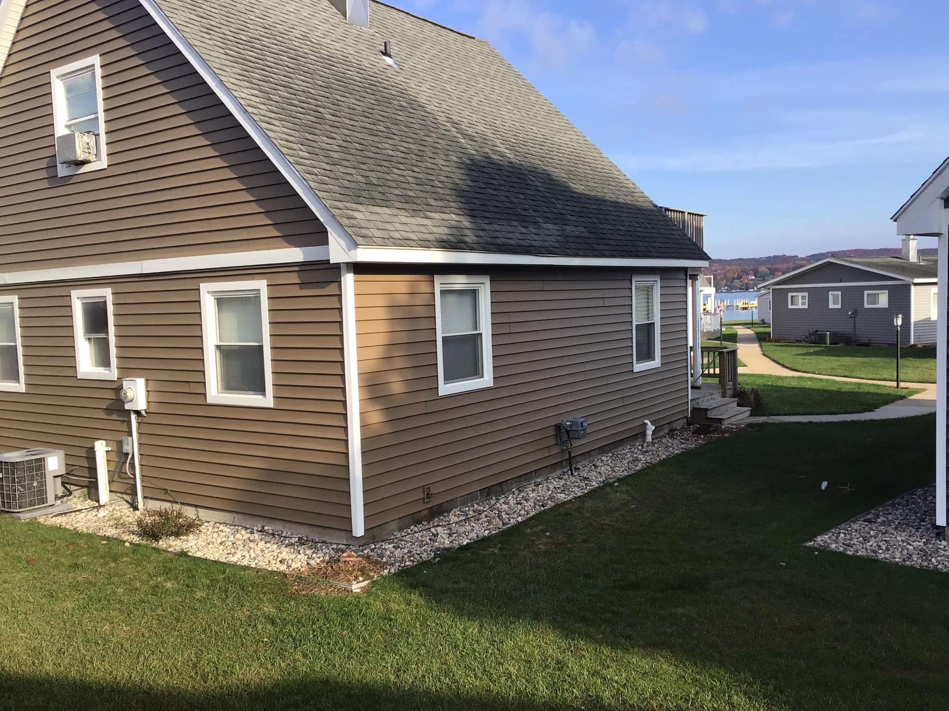 a brown house with a gray roof and white trim