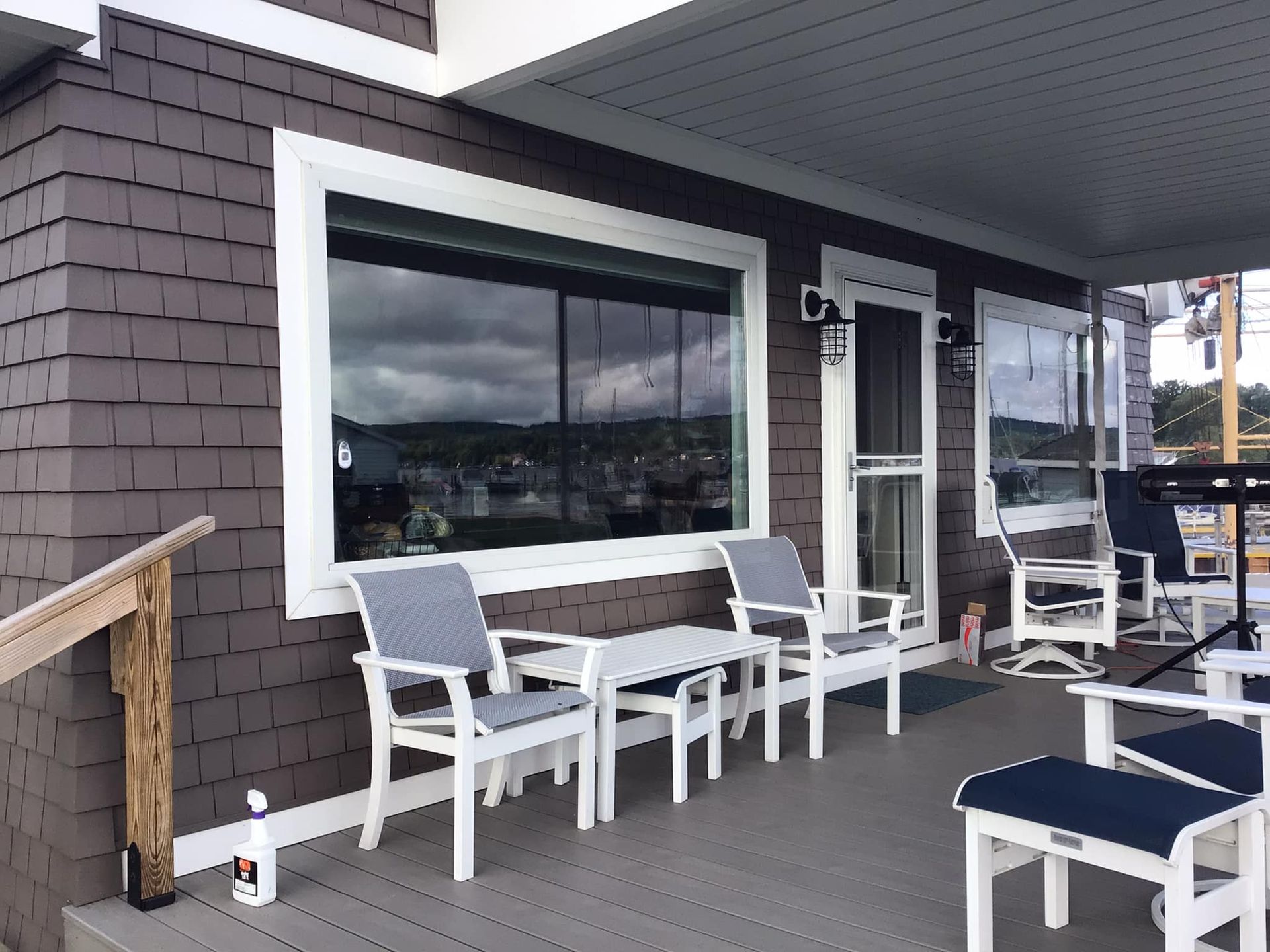 a porch with chairs , a table and a window .