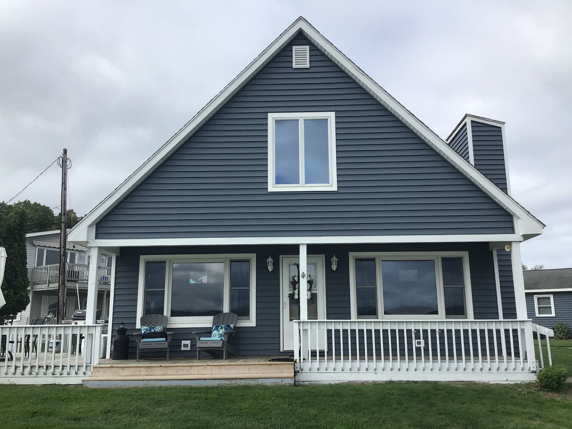 A blue house with white trim and a white porch