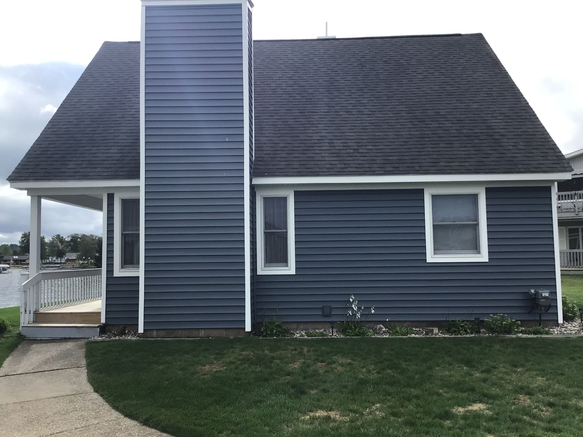 A blue house with a chimney on the side of it.