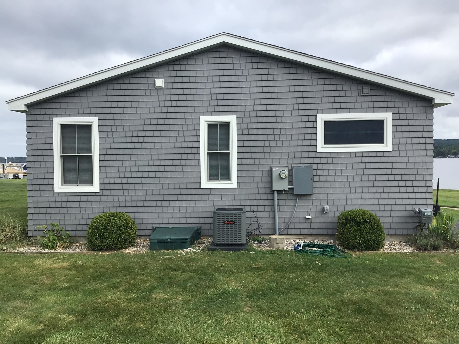 A gray brick house with white trim and windows