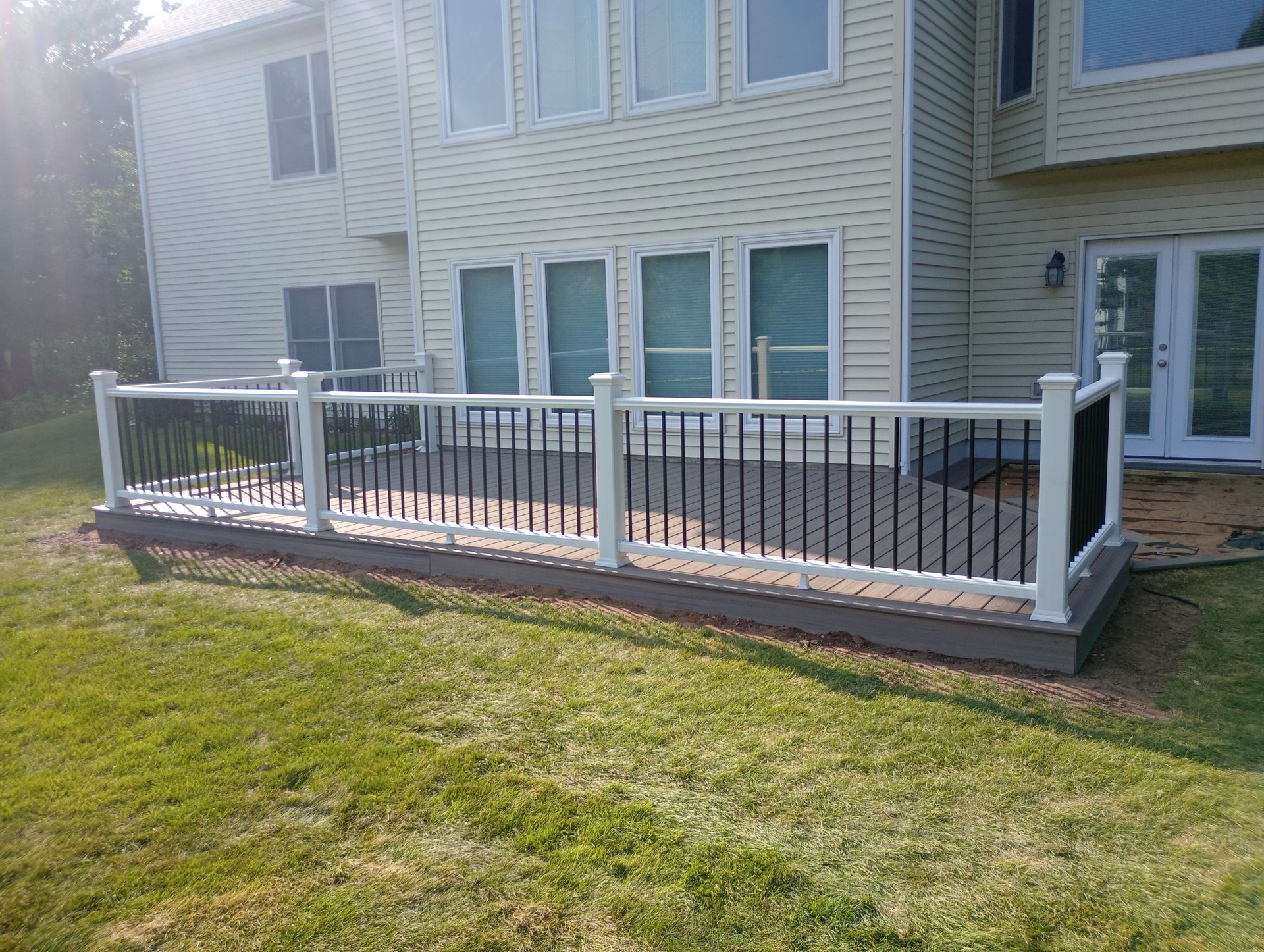 A large white house with a large deck in front of it.