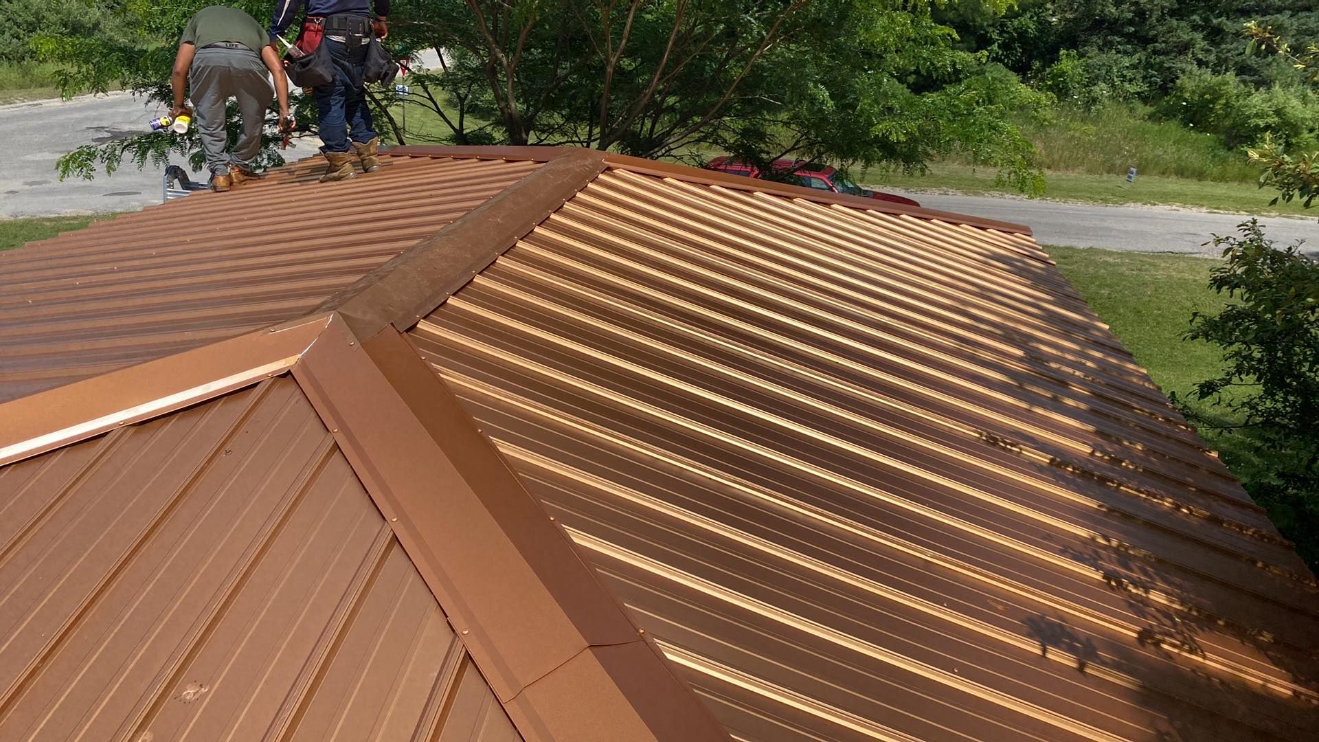A group of men are working on the roof of a house.